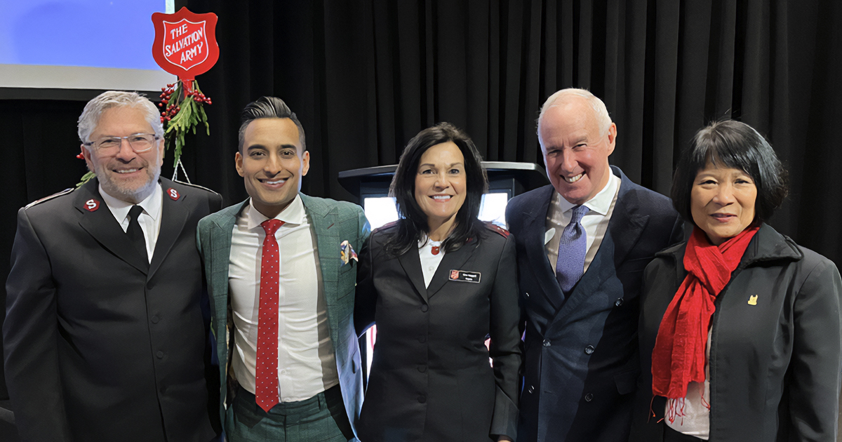 A group of five people standing together smiling