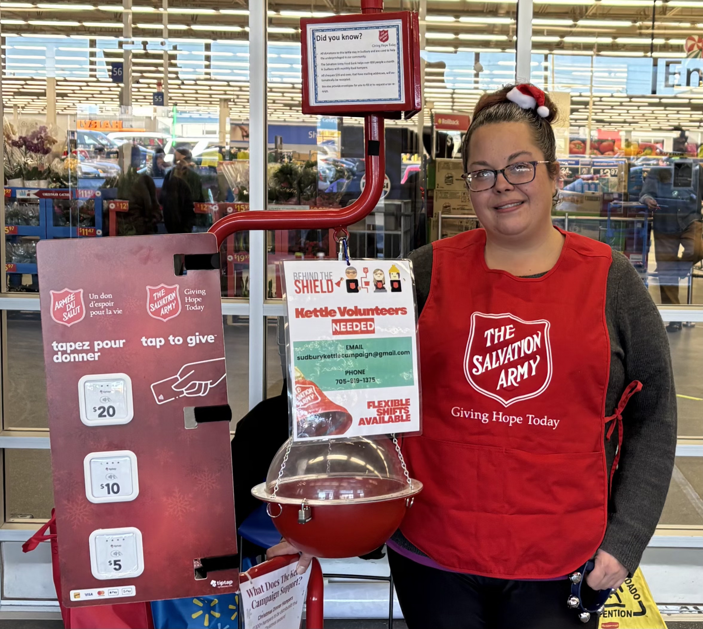 volunteer standing by Christmas kettle