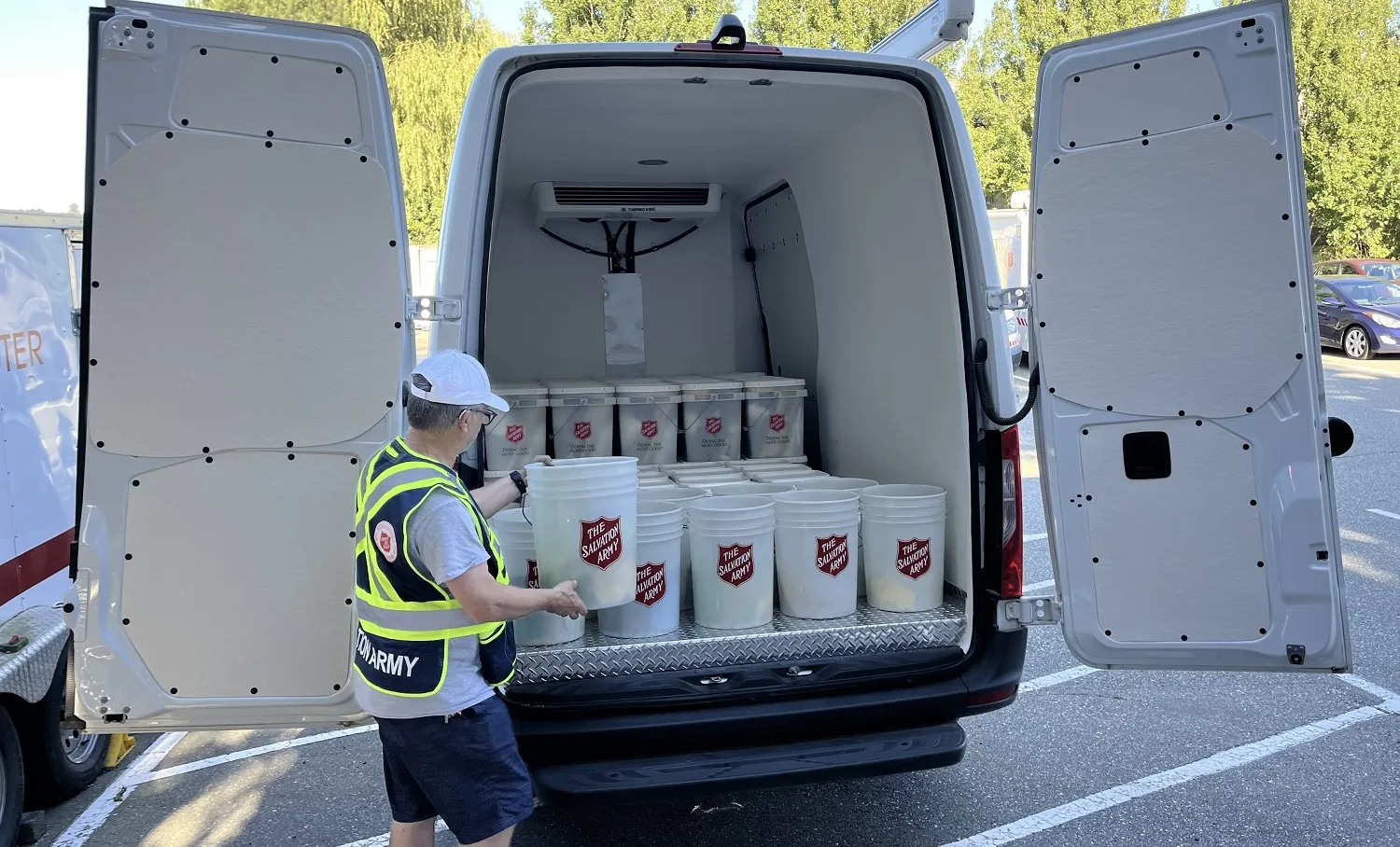 van with volunteer putting buckets in back