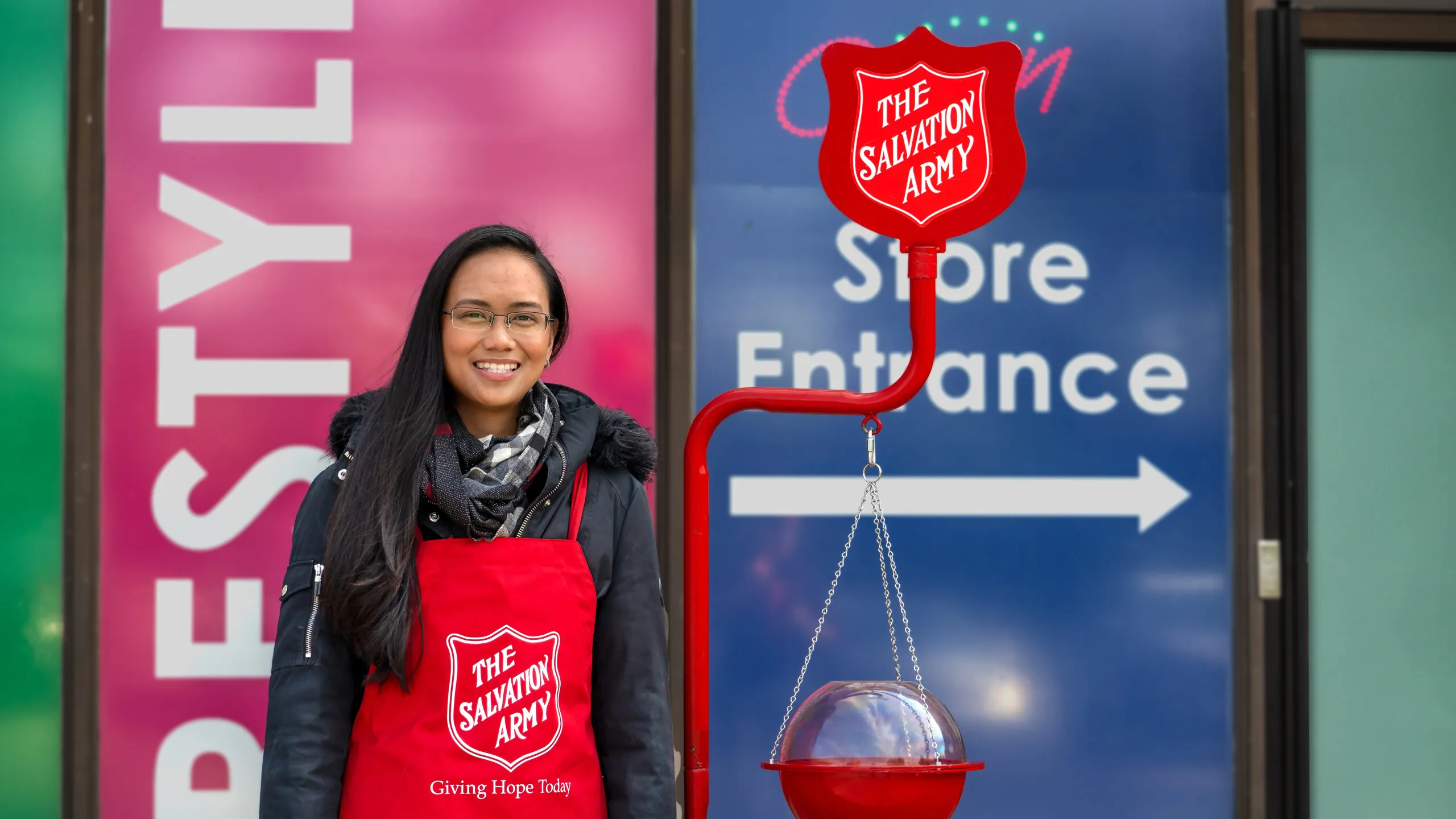 a volunteer standing beside a kettle