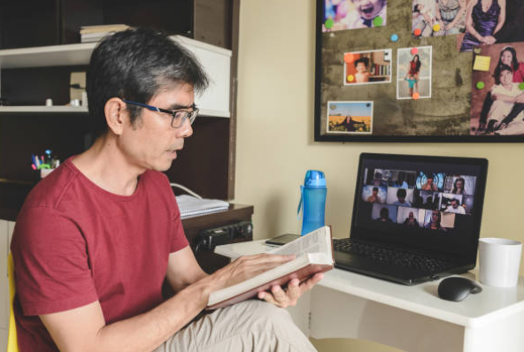 image showing a man reading the scripture whilst attending an online bible study